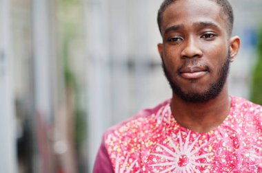 Siyah bir gencin portresi, Afrikalı geleneksel kırmızı renkli kıyafetler giyiyor..