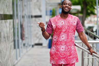 Siyah bir gencin portresi, Afrikalı geleneksel kırmızı renkli kıyafetler giyiyor..