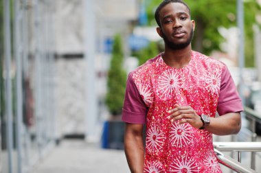 Siyah bir gencin portresi, Afrikalı geleneksel kırmızı renkli kıyafetler giyiyor..