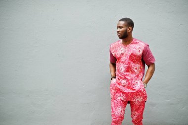 Siyah bir gencin portresi, Afrikalı geleneksel kırmızı renkli kıyafetler giyiyor..