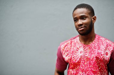 Siyah bir gencin portresi, Afrikalı geleneksel kırmızı renkli kıyafetler giyiyor..