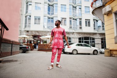 Siyah bir gencin portresi, Afrikalı geleneksel kırmızı renkli kıyafetler giyiyor..