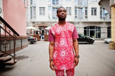 Siyah bir gencin portresi, Afrikalı geleneksel kırmızı renkli kıyafetler giyiyor..