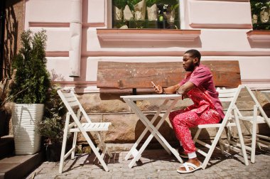 Siyah bir gencin portresi, Afrikalı geleneksel kırmızı renkli kıyafetler giyiyor..