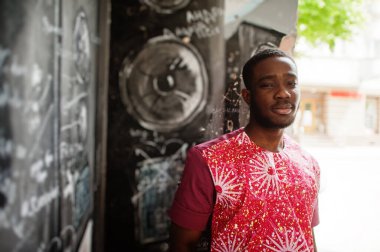 Siyah bir gencin portresi, Afrikalı geleneksel kırmızı renkli kıyafetler giyiyor..