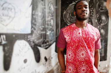 Siyah bir gencin portresi, Afrikalı geleneksel kırmızı renkli kıyafetler giyiyor..