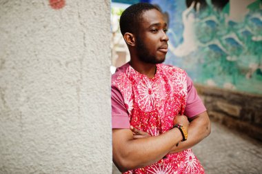 Siyah bir gencin portresi, Afrikalı geleneksel kırmızı renkli kıyafetler giyiyor..