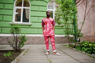 Siyah bir gencin portresi, Afrikalı geleneksel kırmızı renkli kıyafetler giyiyor..