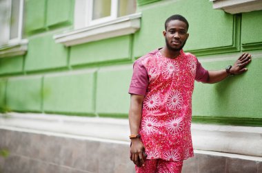 Siyah bir gencin portresi, Afrikalı geleneksel kırmızı renkli kıyafetler giyiyor..