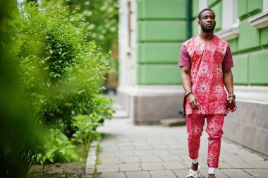 Siyah bir gencin portresi, Afrikalı geleneksel kırmızı renkli kıyafetler giyiyor..