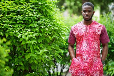 Siyah bir gencin portresi, Afrikalı geleneksel kırmızı renkli kıyafetler giyiyor..