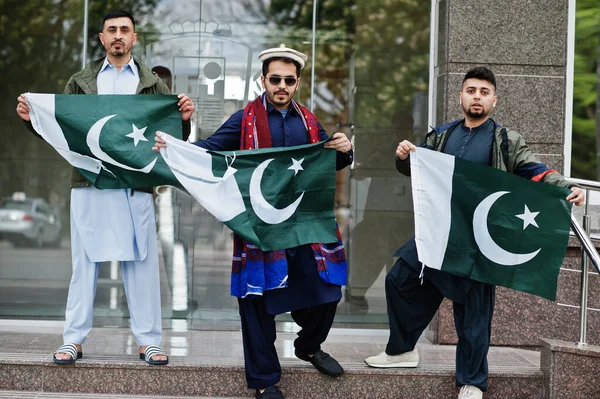 Group of pakistani man wearing traditional clothes salwar kameez or kurta with Pakistan flags.