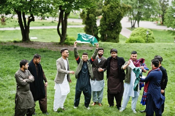 Group of pakistani man wearing traditional clothes salwar kameez or kurta with Pakistan flags.