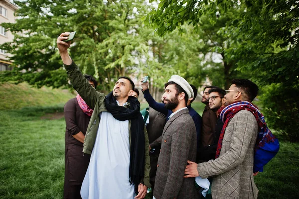 Group of pakistani man wearing traditional clothes salwar kameez or kurta making selfie on mobile phone.