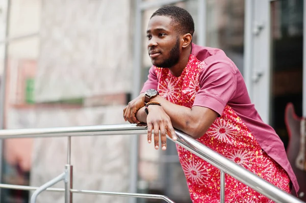 Siyah bir gencin portresi, Afrikalı geleneksel kırmızı renkli kıyafetler giyiyor..