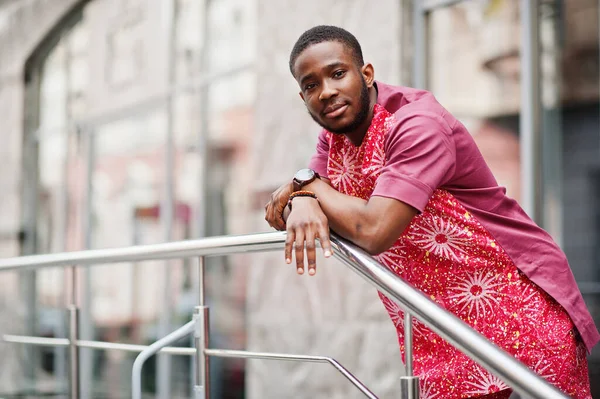 Siyah bir gencin portresi, Afrikalı geleneksel kırmızı renkli kıyafetler giyiyor..