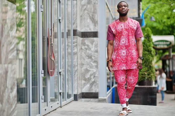 Siyah bir gencin portresi, Afrikalı geleneksel kırmızı renkli kıyafetler giyiyor..