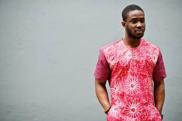 Siyah bir gencin portresi, Afrikalı geleneksel kırmızı renkli kıyafetler giyiyor..