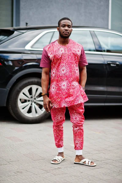 Siyah bir gencin portresi, Afrikalı geleneksel kırmızı renkli kıyafetler giyiyor..