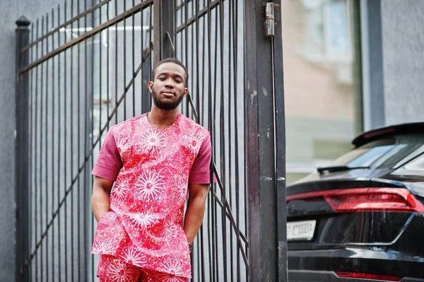 Siyah bir gencin portresi, Afrikalı geleneksel kırmızı renkli kıyafetler giyiyor..