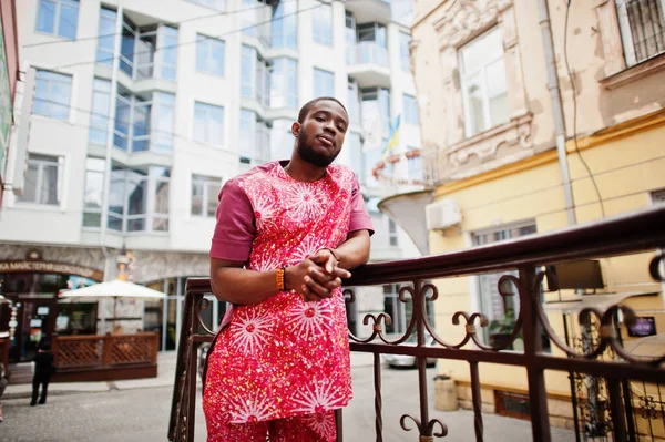 Siyah bir gencin portresi, Afrikalı geleneksel kırmızı renkli kıyafetler giyiyor..