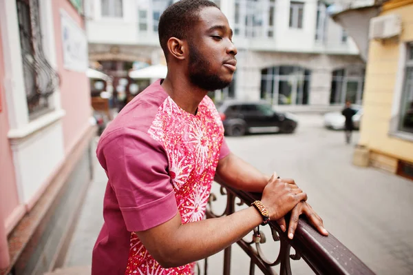 Siyah bir gencin portresi, Afrikalı geleneksel kırmızı renkli kıyafetler giyiyor..