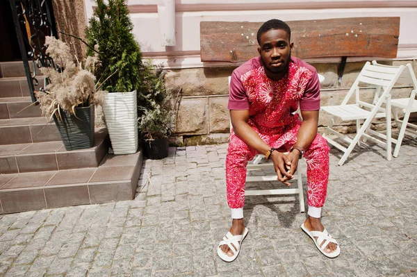 Siyah bir gencin portresi, Afrikalı geleneksel kırmızı renkli kıyafetler giyiyor..