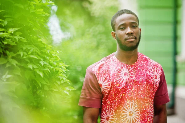 Siyah bir gencin portresi, Afrikalı geleneksel kırmızı renkli kıyafetler giyiyor..