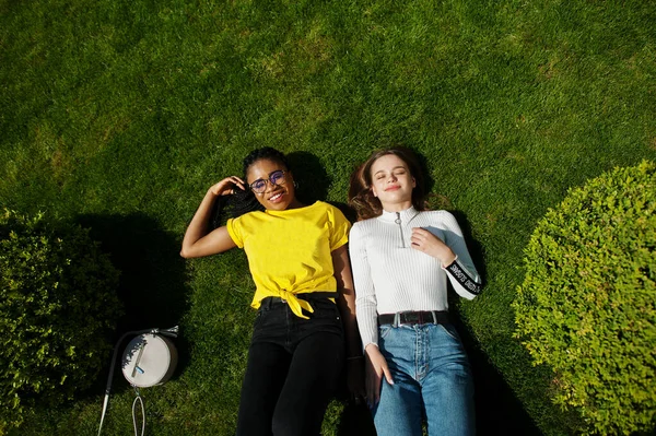 白人白人女孩和黑人非裔美国人躺在草地上 世界团结 种族爱 宽容中的理解和种族多样性合作 — 图库照片