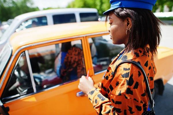 美丽的非洲裔美国女士 戴着太阳镜 站在橙色经典复古车附近 — 图库照片