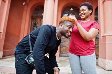 Afrikalı çift dışarıda eğleniyor. Kız arkadaşı erkek arkadaşını tarıyor.