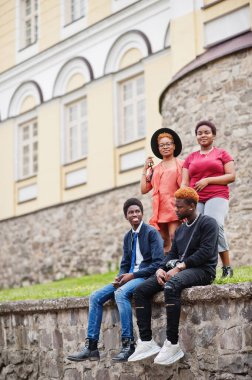 Dört Afrikalı arkadaş dışarıda eğleniyor. İki siyah kız ve erkekler eski bir şehirde oturuyor..