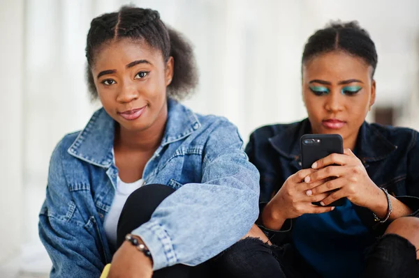 Two African Woman Friends Jeans Jacket Sitting Indoor Together Mobile — Stock Photo, Image