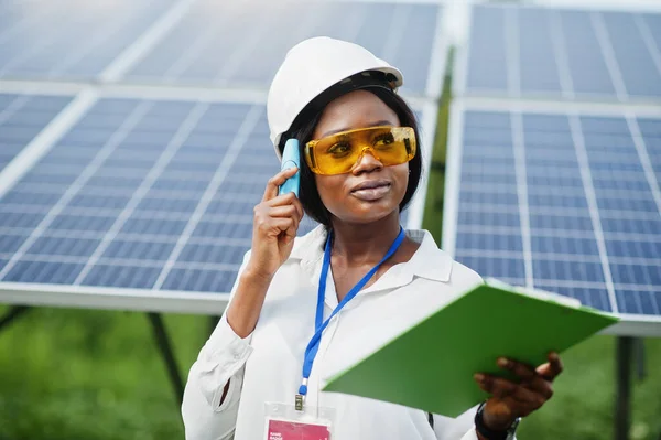 African american technician check the maintenance of the solar panels. Black woman engineer at solar station.