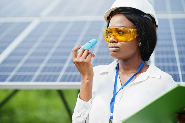 African american technician check the maintenance of the solar panels. Black woman engineer at solar station.