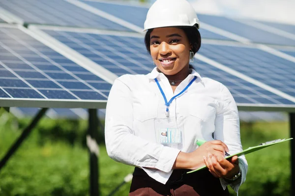 African american technician check the maintenance of the solar panels. Black woman engineer at solar station.