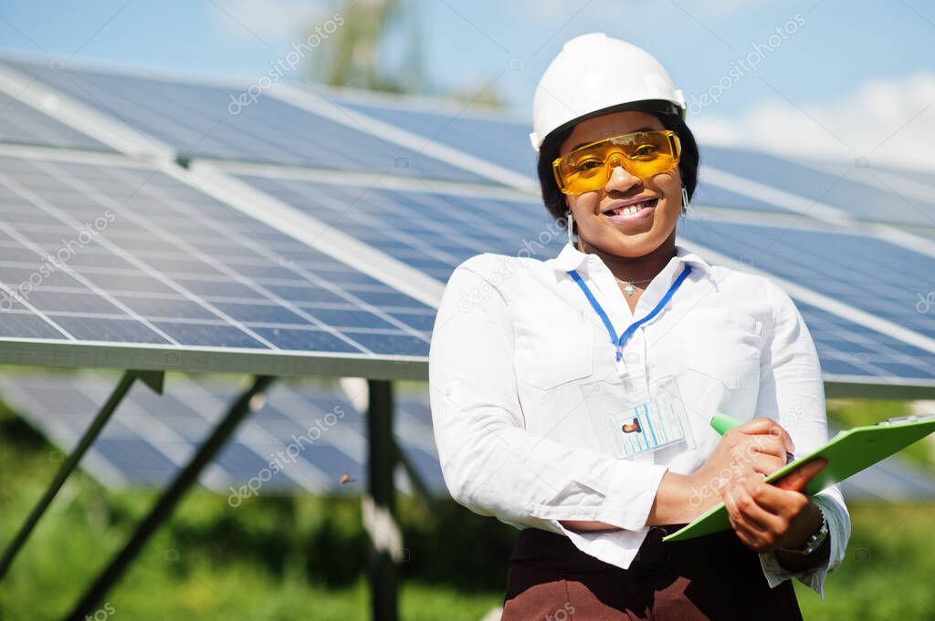 African american technician check the maintenance of the solar panels. Black woman engineer at solar station.