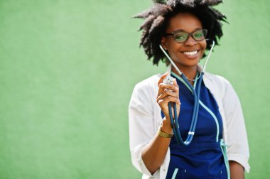 Steteskoplu, laboratuvar önlüğü giyen Afrikalı Amerikalı kadın doktorun portresi..