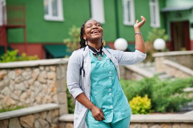 Steteskoplu, laboratuvar önlüğü giyen Afrikalı Amerikalı kadın doktorun portresi..