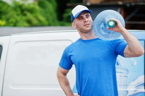 Delivery man in front cargo van delivering bottles of water.