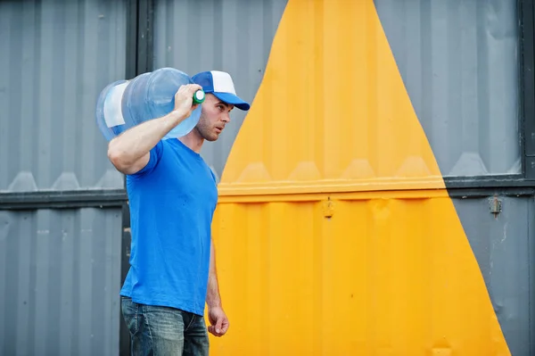 Delivery man carrying water bottle on shoulder.