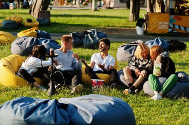 Açık hava sinemasında film izleyen çok ırklı bir grup genç..