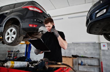 Araba tamiri ve bakım teması. Otomobil servisinde çalışan tamirci, sahibini ara..