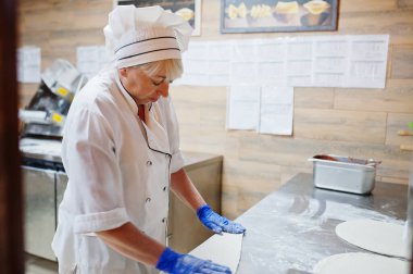 Kadın şef restoran mutfağında pizza hazırlıyor..