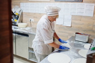Kadın şef restoran mutfağında pizza hazırlıyor..