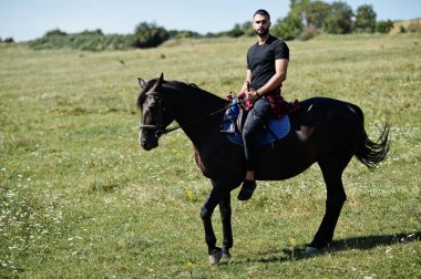 Arap uzun sakallı adam siyah bir Arap atı giyerdi..