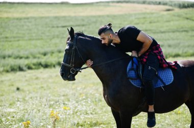 Arap uzun sakallı adam siyah bir Arap atı giyerdi..