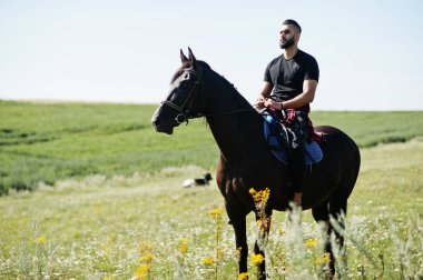 Arap uzun sakallı adam siyah bir Arap atı giyerdi..