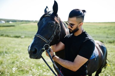 Arap uzun sakallı adam siyah ve güneş gözlüklü Arap atıyla.