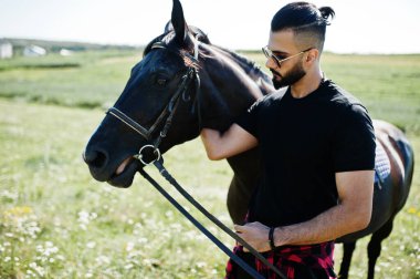 Arap uzun sakallı adam siyah ve güneş gözlüklü Arap atıyla.